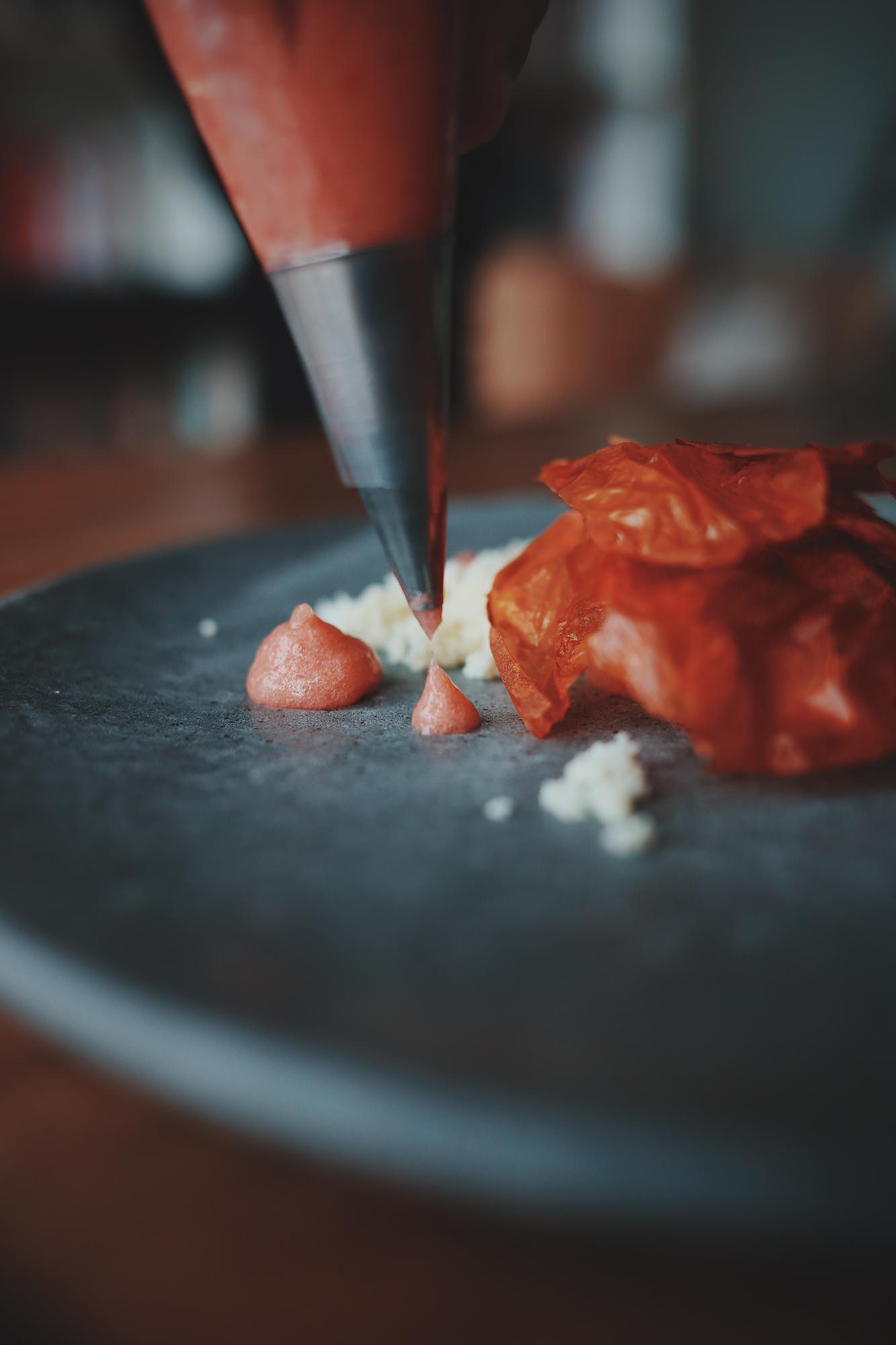 Detalhe de mão do chef a preparar molho